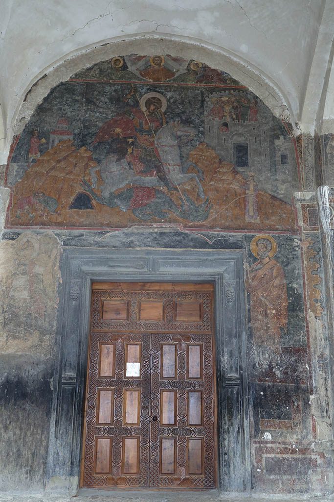 Вход в храм с фресками над дверью